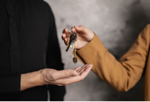 A landlord handing over house keys to their new tenant