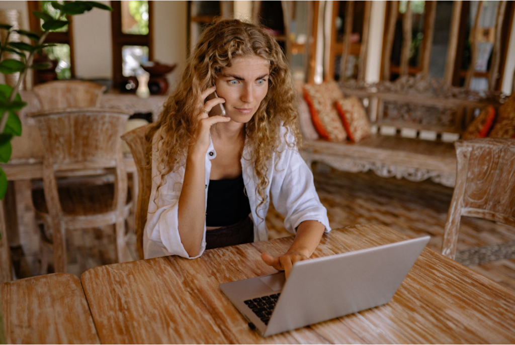 Woman’s eyes opened wide expressing shock while on a phone call