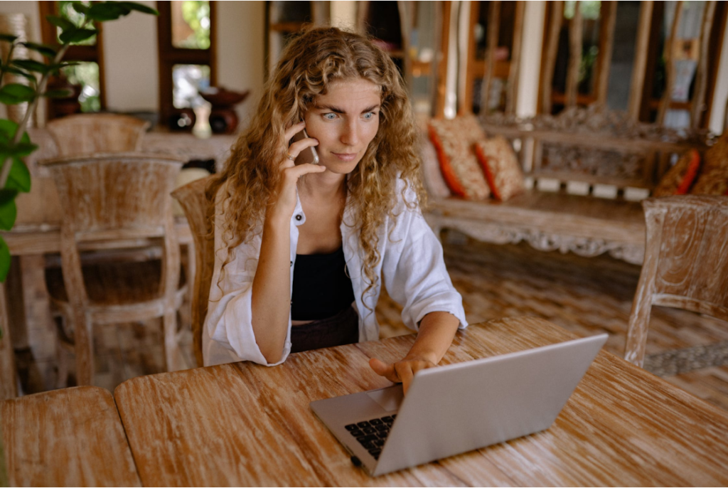 Woman’s eyes opened wide expressing shock while on a phone call
